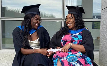 Two students celebrate their graduation.